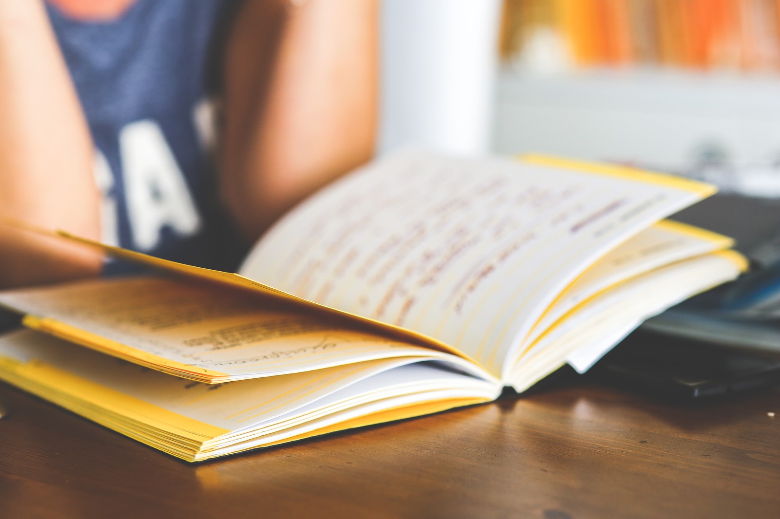 Aufgeschlagenes Buch auf einem Holztisch